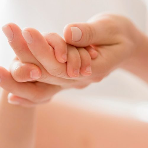 close-up-mom-holding-baby-s-hand_23-2148552545